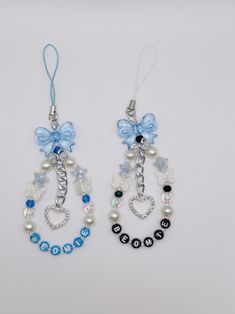 two pairs of earrings with blue bows and beads on them, one is dangling from a chain