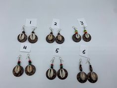 Coconut Shell earrings that come with Rasta beads on top. Available in white or brown cowrie shells. Brown Drop Earrings For Beach, Brown Drop Earrings For The Beach, White Shell-shaped Cowrie Shell Earrings, White Cowrie Shell Earrings, Traditional Brown Jewelry For Summer, Summer Traditional Brown Jewelry, Handmade Brown Cowrie Shell Jewelry, Handmade Brown Shell-shaped Jewelry, Brown Beaded Drop Earrings For Beach