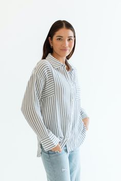 Stay cool and stylish this summer with our Zuma Button Down, featuring pretty iridescent buttons and a raw hem. This super lightweight top offers an effortless, relaxed, and roomy fit, making it perfect for warm weather. Best of all? Its 100% cotton! Wear it buttoned up for a polished look or unbuttoned over a swimsuit or tank for a breezy, casual vibe. This versatile piece is a must have summer staple! Malibu Collection FIT Relaxed Roomy Fit Iridescent Buttons High-Low Raw Hem Clancy is 5'9 Wea Casual Beach Shirt With Button Cuffs, Linen Shirt With Shirttail Hem For Day Out, Casual Shirt With Button Cuffs For Beach, Relaxed Fit Beach Top With Shirttail Hem, Beach Shirttail Hem Top With Relaxed Fit, Beach Tops With Relaxed Fit And Shirttail Hem, Effortless Linen Tops For Day Out, Vacation Button-up Tops With Button Cuffs, Button-up Tops With Button Cuffs For Vacation