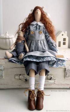 a doll sitting on top of an old suitcase