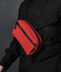 a man wearing a red and black fanny bag