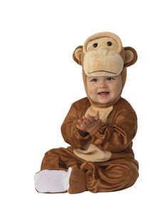 a baby in a monkey costume sitting on the ground with his hands clasped to his chest