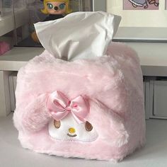 a pink stuffed animal with a tissue dispenser on it's head