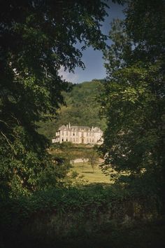 an old house is seen through the trees