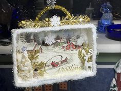 a christmas decoration hanging from the side of a glass case with santa's sleigh on it