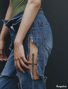 a woman with a cross tattoo on her lower back, showing that it is ripped