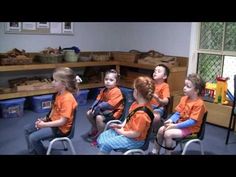 several children sitting in chairs and talking to each other