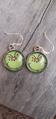 Adorable Round Grinch Face Earrings On Sterling Silver Earwires.Handmade - Shipped From Saint Louis, MO. Grinch Face Earrings, Fun Nickel-free Silver Earrings, Fun Round Ear Wire Jewelry, Novelty Metal Earrings With Ear Wire, Fun Round Earrings As A Gift, Fun Green Round Jewelry, Adjustable Themed Earrings With Ear Wire, Fun Hoop Earrings With Ear Wire As A Gift, Themed Adjustable Earrings With Ear Wire