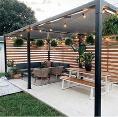 a covered patio with seating and potted plants