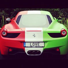 a red, white and green sports car parked on the street