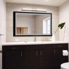 a bathroom with a sink, mirror and toilet paper roll on the counter next to it