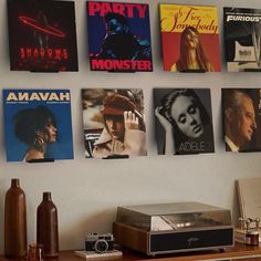 there are many movie posters on the wall next to an old stereo and record player