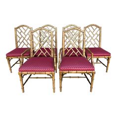 four bamboo chairs with pink upholstered cushions