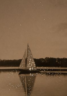 a sailboat with lights on it is in the water