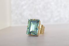 EMERALD CRYSTAL RING, Emerald Cut Ring, Rhinestone Green Gold Feather Ring, Gift for Bridesmaid, Wedding jewelry, Trending jewelry Details of ring: Metal: 24 k Gold plated The stone is 13*18 mm Gemstone: crystals Adjustable ring The ring will be packed in a gift box. , FOR MY RINGS COLLECTION: https://www.etsy.com/il-en/shop/rebekajewelry?ref=hdr_shop_menu&section_id=14282915 FOR MY JEWELRY SET COLLECTION: https://www.etsy.com/il-en/shop/rebekajewelry?ref=hdr_shop_menu&section_id=1958371 Elegant Faceted Crystal Ring For Wedding, Elegant Faceted Crystal Wedding Ring, Jewelry Trending, Emerald Cut Ring, Ring Emerald Cut, Emerald Crystal, Trending Jewelry, Jewelry Details, Feather Ring