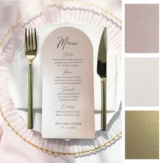 a table setting with silverware and menu cards on it, along with gold rimmed utensils