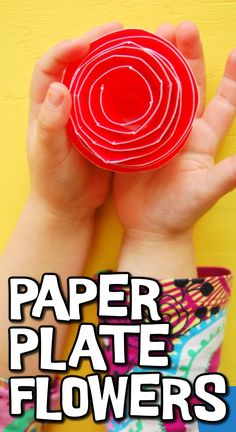 a hand holding a red paper plate with the words paper plate flowers on it