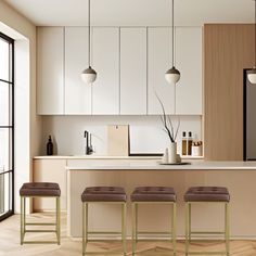 three stools in front of a kitchen island with four lights hanging over the top