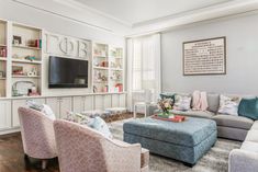 a living room filled with furniture and a flat screen tv mounted to the side of a wall