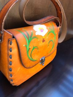 With the floral embroidery trend taking over the fashion scene, these bags with their floral work painted over the leather bag lends an eye-catching detail that is very bohemian. Over rustic brown leather canvas, the colored petals enliven the worn look of these RETRO style bags. The shape of the bag itself is a favorite as it is easy to carry and quite aesthetically-attractive. As the cooler season takes shape, these bags would be fitting for outfits that are earthy in hues. Or if you simply wa Spring Gift Rectangular Satchel, Artistic Bags For Everyday Use In Spring, Brown Shoulder Bag Gift For Spring, Brown Shoulder Bag As Spring Gift, Vintage Hand Painted Rectangular Bag, Vintage Leather Bags For Spring, Spring Satchel Shoulder Bag As Gift, Unique Rectangular Shoulder Bag, Spring Season Shoulder Bag Satchel As A Gift