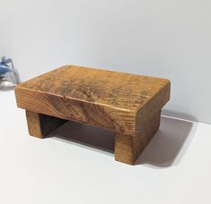 a small wooden stool sitting on top of a white table