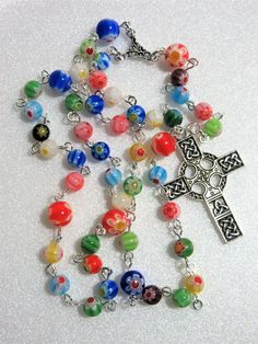 This multi colored millefiori Lutheran rosary is made with 6 and 8mm millefiori glass beads. It is rich in colors including red, blue, aqua, green, yellow, and even a black bead or 2. This rosary measures about 20 inches around and has 5 inch cross drop. I hand turned the silver plated links. The rosary parts are pewter. This rosary will be slipped into a velvet pouch and shipped in a bubble mailer. Multicolor 8mm Beads Rosary As Gift, Multicolor Rosary With 8mm Beads As Gift, Multicolor Beaded Rosary As Gift, Colorful Beads Rosary As Gift, Multicolor Handmade Rosary As Gift, Handmade Multicolor Rosary As A Gift, Handmade Multicolor Rosary As Gift, The Rosary, Bubble Mailer