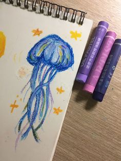 two crayons are next to a drawing of a jellyfish