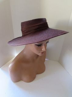 "Attractive vintage hat--a wide brim in chocolate brown weave. Perfect for spring and summer, it promises protection from the sun in addition to being a fashionable accessory.  It has a high crown at 2 3/4\". A crepe 1 3/4\" pleated band circles the crown and forms a tab at the back. Unusual feature on the inside is 2 angled bands, presumably to assist in anchoring to the head.  No maker label.  This could be as late as the early 2000's , but its design is classic Size: 4 3/4\" wide brim; 15 1/2\" wingspan; 20\" inner band circumference Condition: very good vintage, Note--the right side brim is tipping down--this is due to storage. We will use a steamer to correct that prior to shipping,  shipping may result in the same outcome, however.  Price: $38 #107390a Note the wide wingspan will req Brown Weave, Spring Hat, Spring Hats, Hat Summer, Vintage Hat, Summer Hat, Summer Hats, Wide Brimmed, Hats Vintage