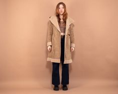 "Vintage 90's women's hooded midi-length Penny Lane style coat with a sherpa (faux sheepskin) lining and trim. Fastens with an inner tie and one-piece toggle button, has a large shawl collar,  a hood and two side-entry pockets. Made of soft faux suede in beige. Vintage condition level 7.5/10. Shows some signs of wear - has some dark spots at the lower front; the sherpa fabric is a bit matted. Model Agnese is 5'8 ft (1.78 m), 152 lbs (69kg) and she wears the size available. SIZE: Estimated size S. To be sure it would fit, please check the measurements below.  FLAT Measurements : Length: 38\" / 97 cm  Armpit to armpit: 19\" / 48 cm Shoulder to shoulder: 16 1/2\" / 42 cm Sleeve: 25\" / 63.5 cm SKU - V6674 Every item is authentic vintage, one-of-a-kind. You will receive the exact item shown in Vintage Hooded Jacket For Cold Fall Weather, Retro Hooded Winter Outerwear, Vintage Hooded Parka For Fall, Vintage Hooded Outerwear For Cold Weather, Retro Hooded Parka For Fall, Retro Hooded Fall Parka, Vintage Hooded Outerwear With Double-lined Hood, Vintage Parka With Double-lined Hood For Fall, Vintage Hooded Outerwear For Fall