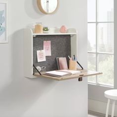 a white desk with a clock on the wall above it and some papers in front of it