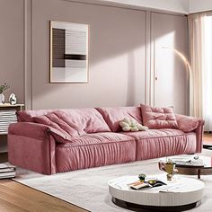 a living room with pink couches and white rugs on the hardwood flooring