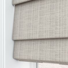 a beige roman blind in front of a window