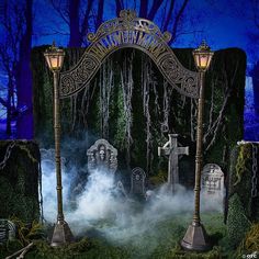 a halloween display with tombstones and candles in the middle of a forest at night