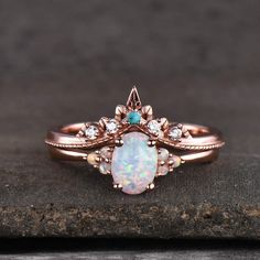 an opal and diamond ring on top of a rock