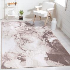 a white chair sitting next to a rug on top of a floor