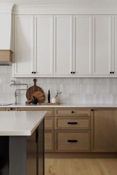 a kitchen with wooden cabinets and white counter tops, along with an island in the middle