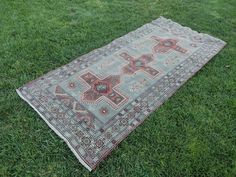 an old rug is laying in the grass on top of some green grass and there are no people around it