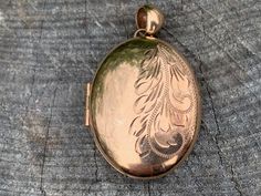 "Set in 9k yellow gold this lavish vintage oval locket is a classic. It dates from the 1940s. Beautifully engraved on one side, this is the essence of elegance. It opens up and has room for 2 pictures. The locket measures 1 3/4\" x 1\". It weighs 12.25 grams. N 659 SIX MONTH LAYAWAY AVAILABLE" Classic Antique Gold Oval Jewelry, Formal Rose Gold Engraved Locket Necklace, Classic Oval Antique Gold Jewelry, Ornate Oval Engraved Locket Necklace, Ornate Engraved Oval Locket Necklace, Victorian Engraved Oval Cabochon Jewelry, Elegant Oval Pendant Locket Necklace From Vintage Collection, Elegant Oval Pendant Locket Necklace For Vintage Collection, Elegant Locket Necklace With Antique Finish