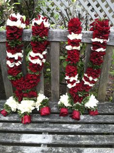 red and white flowers are arranged on the back of a bench