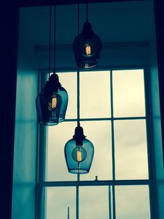 three hanging lights in front of a window