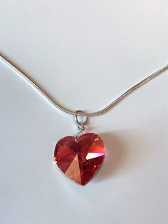 This is a gorgeous and yet simple drop necklace featuring an 18 mm Swarovski Aurora Borealis (AB) padparadscha floating heart. The AB coating enhances the sparkle and glitter of the crystal heart facets. This sterling silver snake chain has a length of 19 inches. The clasp and all the findings are also sterling silver. The necklace weighs 0.27 oz and has a drop of 1-1/4 inch. This will be a fantastic addition to any wardrobe. Wonderfully handcrafted quality at a fantastic price! *Swarovski AB padparadscha crystal rose heart *Sterling silver snake chain *Clasp and all findings are also sterling silver *Length= 19 inches *Drop= 1-1/4 inch *Weighs 0.27 oz. NOTE: No retail box. Item will be safely packed and shipped in a secure bubble bag. Ships only to the U.S. via USPS First-Class. Allow up Valentine's Day Heart Pendant Crystal Necklace, Valentine's Day Heart Pendant Crystal Necklace With Heart Charm, Heart-shaped Crystal Necklace For Valentine's Day Anniversary, Heart Shaped Crystal Necklace For Valentine's Day Anniversary, Valentine's Day Crystal Necklace With Heart Pendant And Charm, Valentine's Day Heart Charm Crystal Necklaces, Silver Heart Cut Crystal Necklace For Valentine's Day, Silver Heart Charm Crystal Necklace For Valentine's Day, Valentine's Day Heart Pendant Crystal Necklace In Sterling Silver