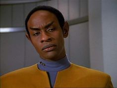 a man in a star trek uniform stares at the camera