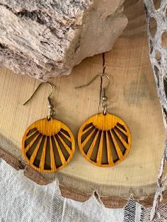 These Sunshine earrings will have you dreaming of the desert. These original designs are cut from Baltic birch, stained with an amber gold dye, and sealed with teak oil. Like all of our earrings, they are made with high quality, nickel free, hypoallergenic, components.. Measures 1.25” x 1.25”. Nature-inspired Brown Earrings With Ear Wire, Brown Dangle Earrings Nature-inspired, Handmade Round Wooden Earrings, Nature-inspired Brown Dangle Earrings, Handmade Wooden Round Earrings, Earthy Natural Wood Jewelry For Gifts, Round Wooden Earrings For Gifts, Wooden Round Earrings For Gifts, Round Wooden Earrings As Gift