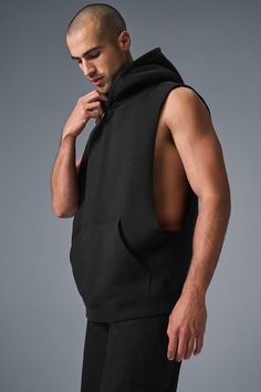 Stay cozy without sacrificing style in the Renown Sleeveless Hoodie. It has deep armholes, a kangaroo pocket, and a laid-back cut. And wait till you feel the Alo signature Renown fabric—it's smooth on the outside, a little fleecy on the side, and heavyweight for a just-right drape. Add shorts and you’re covered from the gym to the street. Cropped Sleeveless Hoodie, Sleeveless Sportswear Hoodie For Streetwear, Stretch Sleeveless Vest With Pockets, Alo Yoga Athleisure Tank Top For Gym, Alo Yoga Sporty Top With Drawstring Hood, Black Hooded Vest For Streetwear, Sleeveless Hoodie For Streetwear, Cotton Hoodie With Pockets For Gym, Sleeveless Hoodie For Streetwear In Athleisure Style