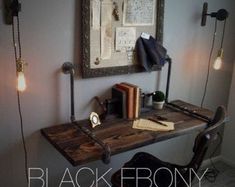 a desk with some books on it and lights hanging from the wall next to it