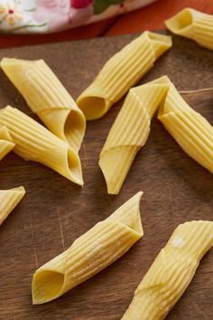 several pieces of pasta sitting on top of a wooden cutting board