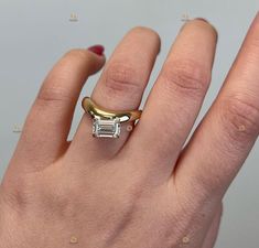 a woman's hand with a gold and white diamond ring on top of it