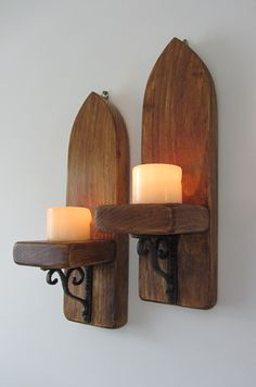 two candle holders are on the wall next to each other