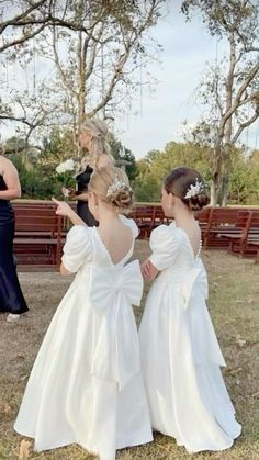 two women in white dresses standing next to each other