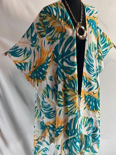 Embrace tropical elegance with our Monstera Print Tropical Style Kimono Blouse, an ideal addition to your summer wardrobe. This lightweight kimono is perfect for resort cruises, beach cover-ups, or any casual summer occasion. The vibrant monstera leaf print captures the essence of tropical paradise, adding a lively and artistic touch that art lovers will appreciate. Crafted from airy, breathable fabric, this summer kimono ensures you stay cool and comfortable even on the hottest days. Its versatile design allows it to transition seamlessly from a chic beach cover-up to a stylish layer over your favorite outfits. The flowing silhouette flatters all body types, and the open front design provides ease of wear and an effortlessly elegant look. Whether you're lounging by the beach, exploring tr Breezy Wrap Cover-up For Vacation, Vacation Beach Cover-up Kimono With Kimono Sleeves, Summer Beach Cover-up Kimono, Multicolor Printed Wrap Cover-up, Oversized Open Front Beach Cover-up, Flowy Wrap Beach Cover-up, Flowy Open Front Beach Cover-up, Blue Floral Print Hawaiian Shirt For Beach, Oversized Wrap Cover-up For Summer